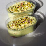 Two pistachio mousse cups topped with pistachios